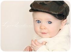 a baby with blue eyes wearing a hat