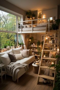 a living room with a loft bed next to a large window and stairs leading up to the second floor