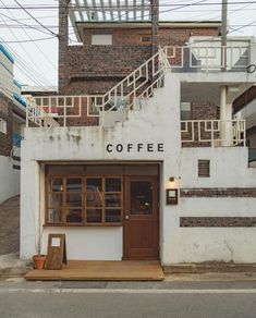 an old coffee shop with stairs leading up to it