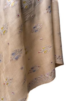 Celebrate the subtle elegance of our "Beige Blossom Tilla Enchantment Pashmina," a shawl that resonates with the gentle beauty of a blossoming garden under the soft Kashmir sun. Adorned with hand-embroidered sozni work, it features delicate motifs inspired by the region's flora, brought to life with a kiss of color and the sparkle of tilla embroidery. Drape yourself in this embodiment of quiet sophistication, a pashmina that complements every occasion with its understated glamour and refined all Luxury Chikankari Embroidered Shawl, Luxury Beige Pashmina Shawl With Embroidered Border, Traditional Cream Pashmina Shawl For Festive Occasions, Traditional Cream Pashmina Shawl, Embroidered Jamawar Pashmina Shawl For Wedding, Wedding Shawl With Chikankari Embroidery In Pashmina, Elegant Pashmina Embroidered Fabric With Zari Work, Embroidered Cream Pashmina Shawl In Traditional Drape, Elegant Pashmina Fabric With Zari Embroidery