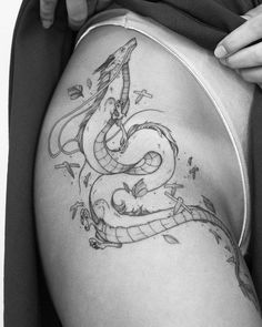 black and white photo of a woman's thigh with a snake tattoo on it