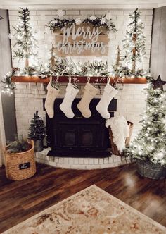 christmas stockings hanging from the mantel in front of a fireplace with lights on it