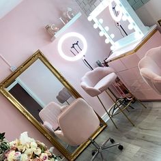 a salon with pink walls, chairs and mirrors