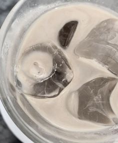 ice cubes are in the bottom of a blender filled with milk and water