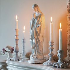 a white mantle with candles and statues on it