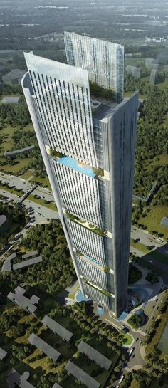 an aerial view of a tall building in the middle of a green area with lots of trees