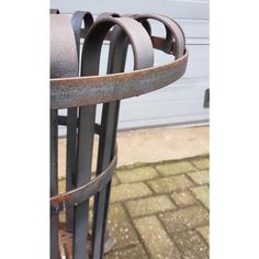 an old metal fence with rings on it's sides and a door in the background