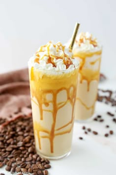 two glasses filled with ice cream and topped with whipped cream, caramel sauce and chocolate chips