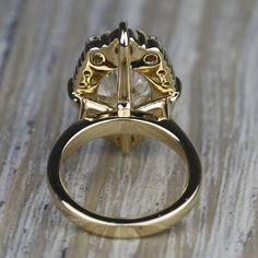 a gold and diamond ring sitting on top of a wooden table