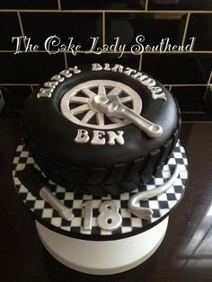 a black and white cake with a tire on top that says the cake lady southern