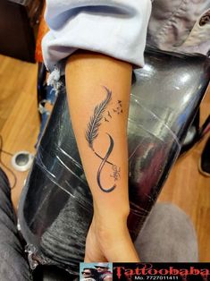 a woman's arm with a tattoo on it and a feather in the middle