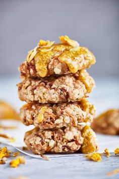 three cookies stacked on top of each other with orange zest around the edges and oatmeal toppings