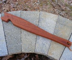 a piece of wood sitting on top of a brick wall next to leaves and fallen leaves