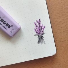 a purple pen sitting on top of a notepad next to a small eraser