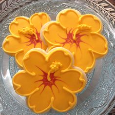 four decorated cookies sitting on top of a glass plate