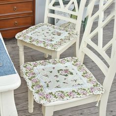 two white chairs sitting on top of a wooden floor next to a dresser and chair