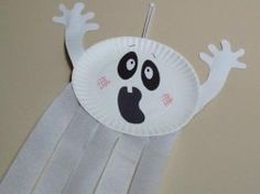 a paper plate ghost hanging from a wall