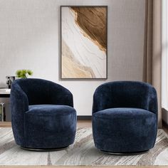 two blue chairs sitting next to each other in front of a painting on the wall