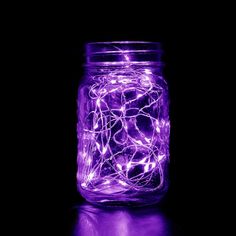 a mason jar filled with purple fairy lights