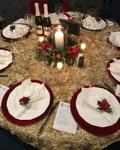 a table set for christmas dinner with candles and place settings