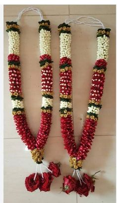 two red and white flowers are attached to some beads