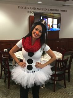 a woman dressed as a snowman poses for a photo in front of a table