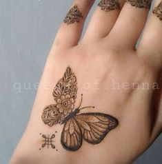 a woman's hand with a butterfly tattoo on it