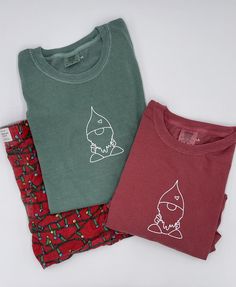 I absolutely LOVE this holiday tee. The Gnome Short Sleeve Tee is absolutely adorable and a great for the holidays. - One of the things I love about comfort colors is that their tees can be worn for really any occasion! I love this gnome tee paired with my Christmas shorts as a super cute pj set! The tee is SO SOFT!  Material: 100% Cotton, White Premium Heat Transfer Vinyl  Color: Red, Green Brand: Comfort Colors Fit: True to size, can be worn oversized or fitted :) ~ model 5'9 is wearing size: Cute Winter T-shirt For Loungewear, Soft-washed Crew Neck T-shirt As Gift, Christmas Cotton T-shirt For Loungewear, Christmas Cotton Top With Screen Print, Christmas Cotton Tops With Screen Print, Christmas Cotton Loungewear Tops, Gnome Shirts, Unisex Christmas Gifts, Green Brands