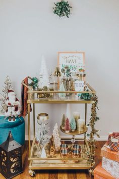 a gold cart with christmas decorations on top and presents under the shelf next to it