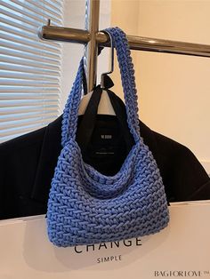 a blue crocheted bag hanging from a coat rack in front of a window