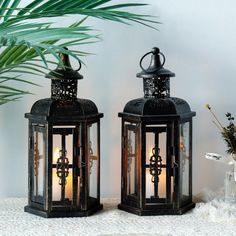 two black lanterns sitting on top of a table