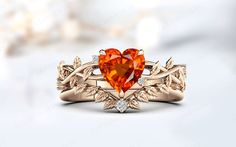 an orange heart shaped diamond ring with leaves on the band and diamonds in the setting