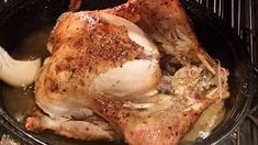 a close up of a chicken in a pan on the stove