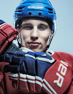 a young man wearing a blue and red hockey uniform