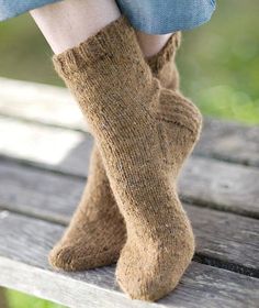 a woman's legs with socks on sitting on a bench