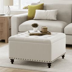 a living room with a white couch and ottoman