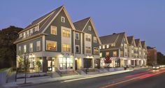 a row of townhouses at night with street lights