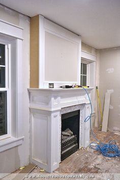 an unfinished room with a fireplace and windows