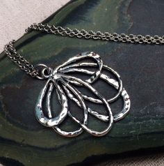 This is such a fun and unique silver flower necklace.  It is modern and whimsical in it’s detail and design.  Perfect for everyday wear and very versatile in style.  The pendant measures 1 1/4” long by 1” wide and hangs from a simple 18” stainless steel necklace chain.  I have matching earrings in my shop, if you would like the whole set.  Here is the link........ https://etsy.me/2A7CZDF Thanks for stopping by!  Please take a moment and visit the rest of my Etsy shop.  I have many more unique je Bohemian Sterling Silver Flower Necklace, Silver Necklace With Nature-inspired Flower Charm, Silver Metal Necklace In Flower Shape, Silver Nature-inspired Necklace With Flower Charm, Silver Flower-shaped Metal Necklace, Silver Flower Shaped Metal Necklace, Nature-inspired Silver Flower Necklace With Charm, Sterling Silver Adjustable Flower Pendant Necklace, Adjustable Sterling Silver Flower Pendant Necklace