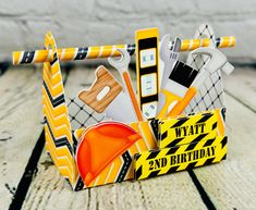 a construction themed birthday card holder on a wooden table with scissors, hammers and other items