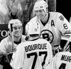 the hockey players are talking to each other in front of an official sign that says, bourque 77