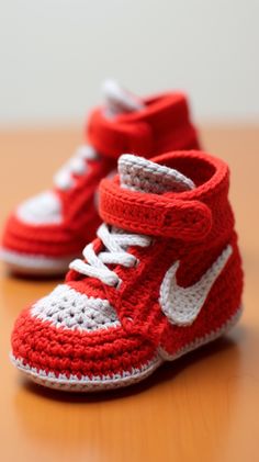 two crocheted sneakers sitting on top of a wooden table