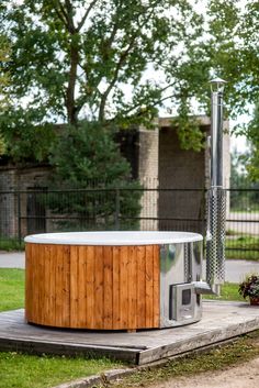 a hot tub sitting on top of a wooden platform in front of a fenced area