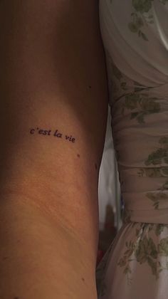 the back of a woman's arm with a tattoo saying, east for we