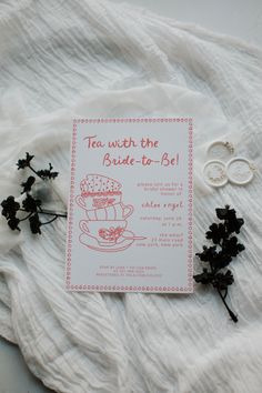 the wedding stationery is laid out on white fabric