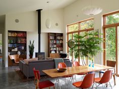 a living room filled with lots of furniture next to a window covered in bookshelves