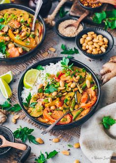 three black bowls filled with thai food and garnished with cilantro, limes, cashews