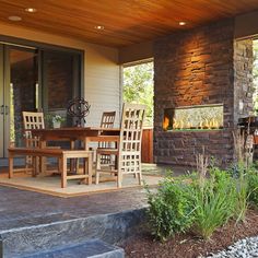 a patio with chairs, table and fire place