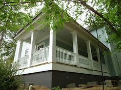 a white house sitting on top of a lush green hillside