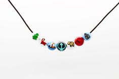 a necklace that has different colored beads on the front and back of it, including letters